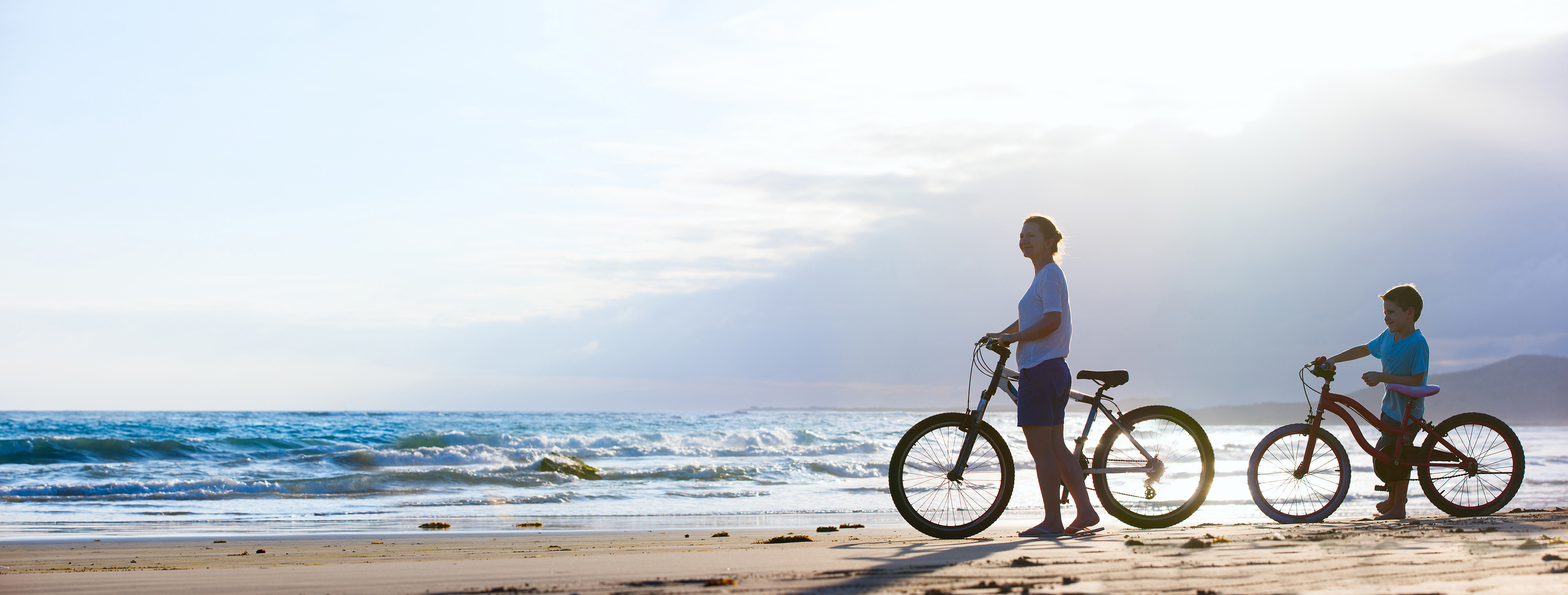 Family cycling on the beach during holiday